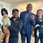 Dr Christopher Giza, boxing legend Evander Holyfield and members of the UCLA boxing team, posing for the camera