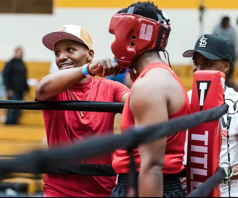 Devon Alexander adjusting the headgear of a boxer before his fight