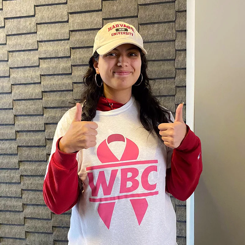 Young woman wearing t-shirt with a WBC logo on top of a pink ribbon, supporting the cancer awareness month
