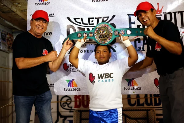 Student from Sick Vic & Meño’s gym posing with a WBC Champion belt replica, alongside Manuel 'Mantecas' Medina and Cleto reyes member