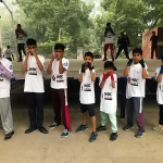 Kunal Goyat's students doing a boxing pose, wearing WBC Cares T-shirts