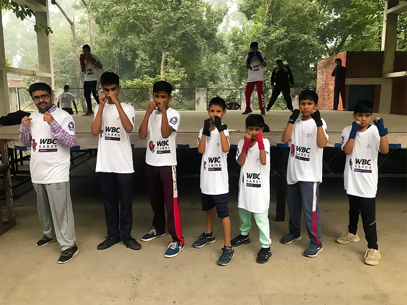 Kunal Goyat's students doing a boxing pose, wearing WBC Cares T-shirts