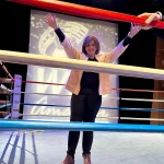 Marcela Orvañanos, founder and chair of Qualitas of Life, posing with her arms up on top of the ring