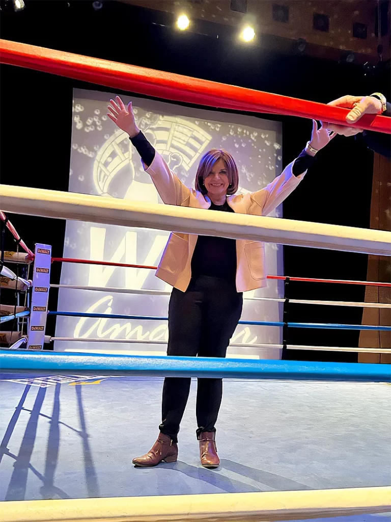Marcela Orvañanos, founder and chair of Qualitas of Life, posing with her arms up on top of the ring