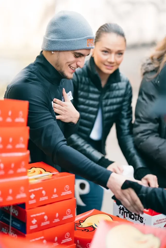 Boxer Christopher Guerrero and Noemie Charest serving plates for the community