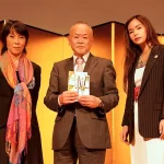 Chisa Yamane, Mr. Kashimi, Nabhiraks (Jade) Bhakdibhumi, posing for the camera at the ceremony displaying the funds collected at the fundraise